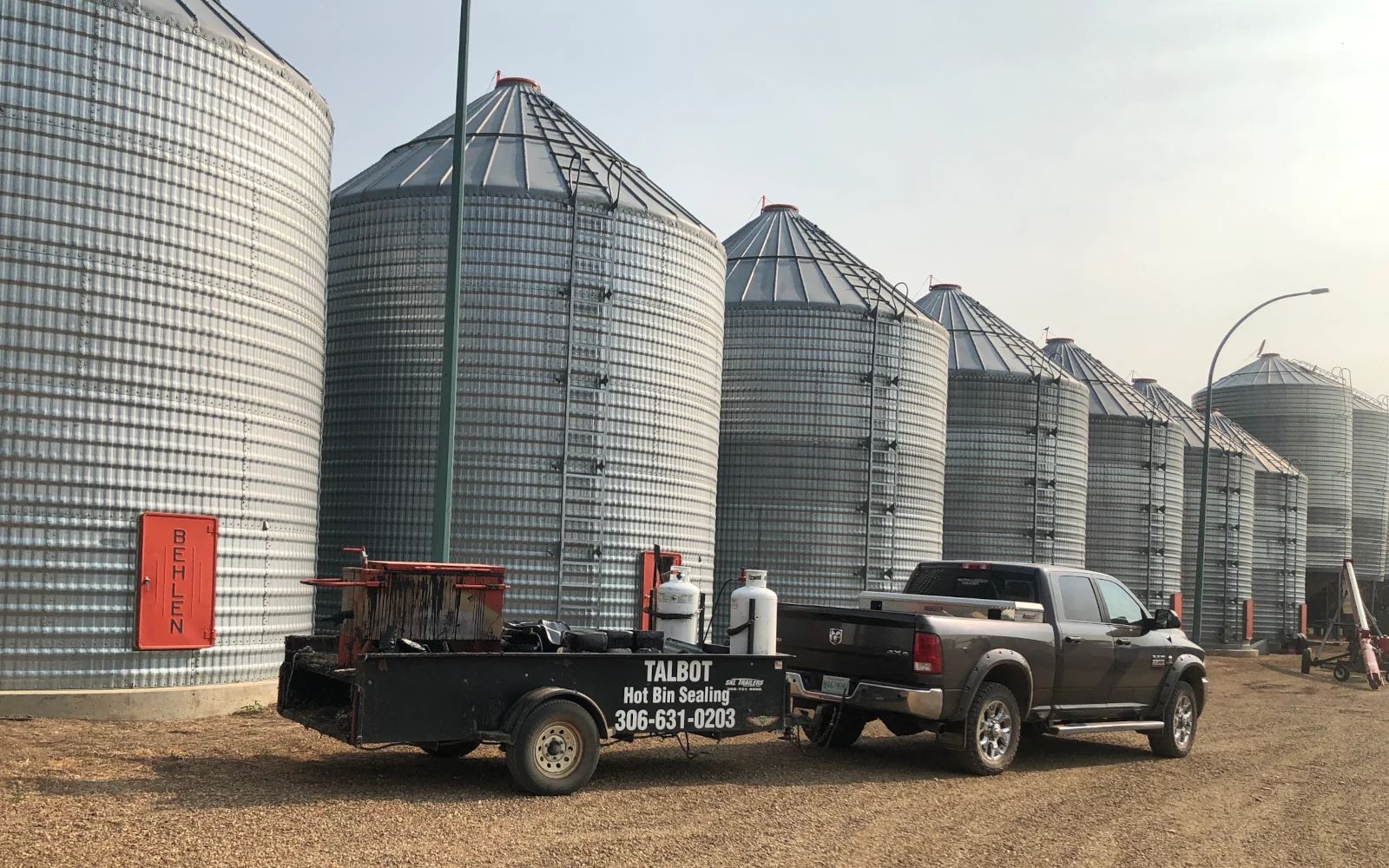 talbot truck and trailer in front of grain bins